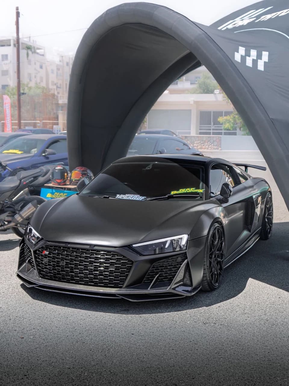 Black Audi R8 photographed beneath an event canopy